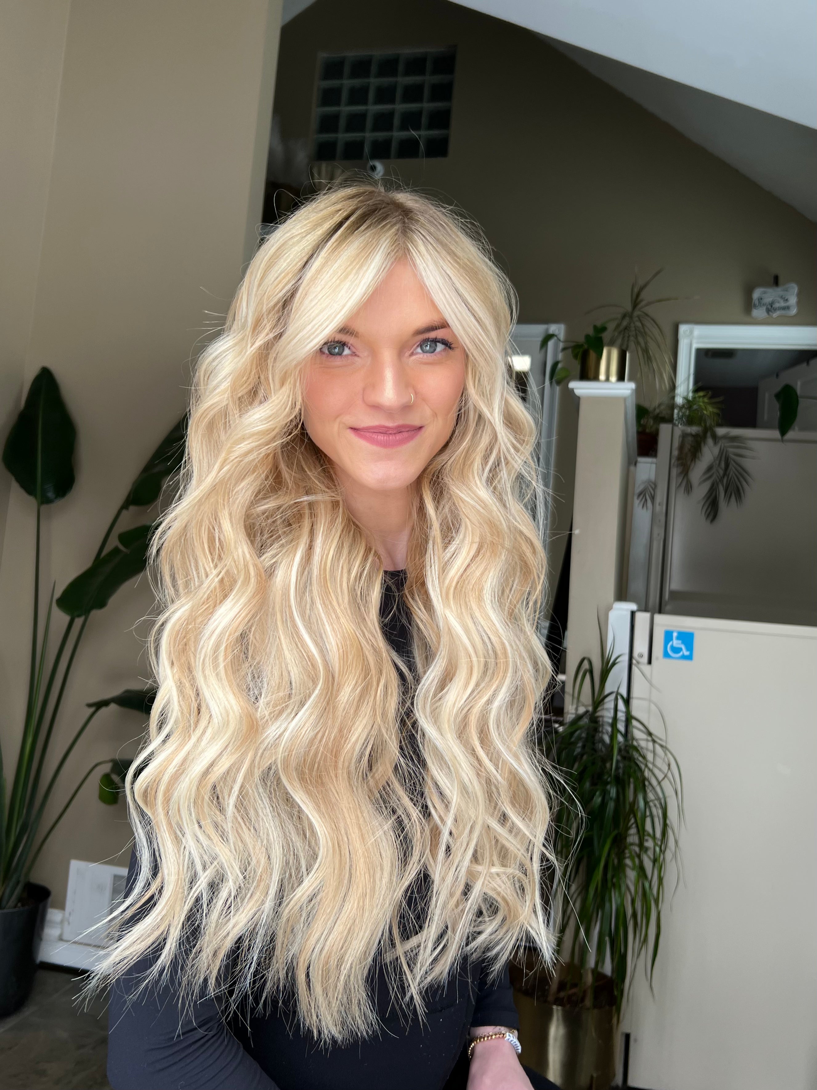 Client with Stitched Seam Weft™ extensions — voluminous, wavy blonde hair