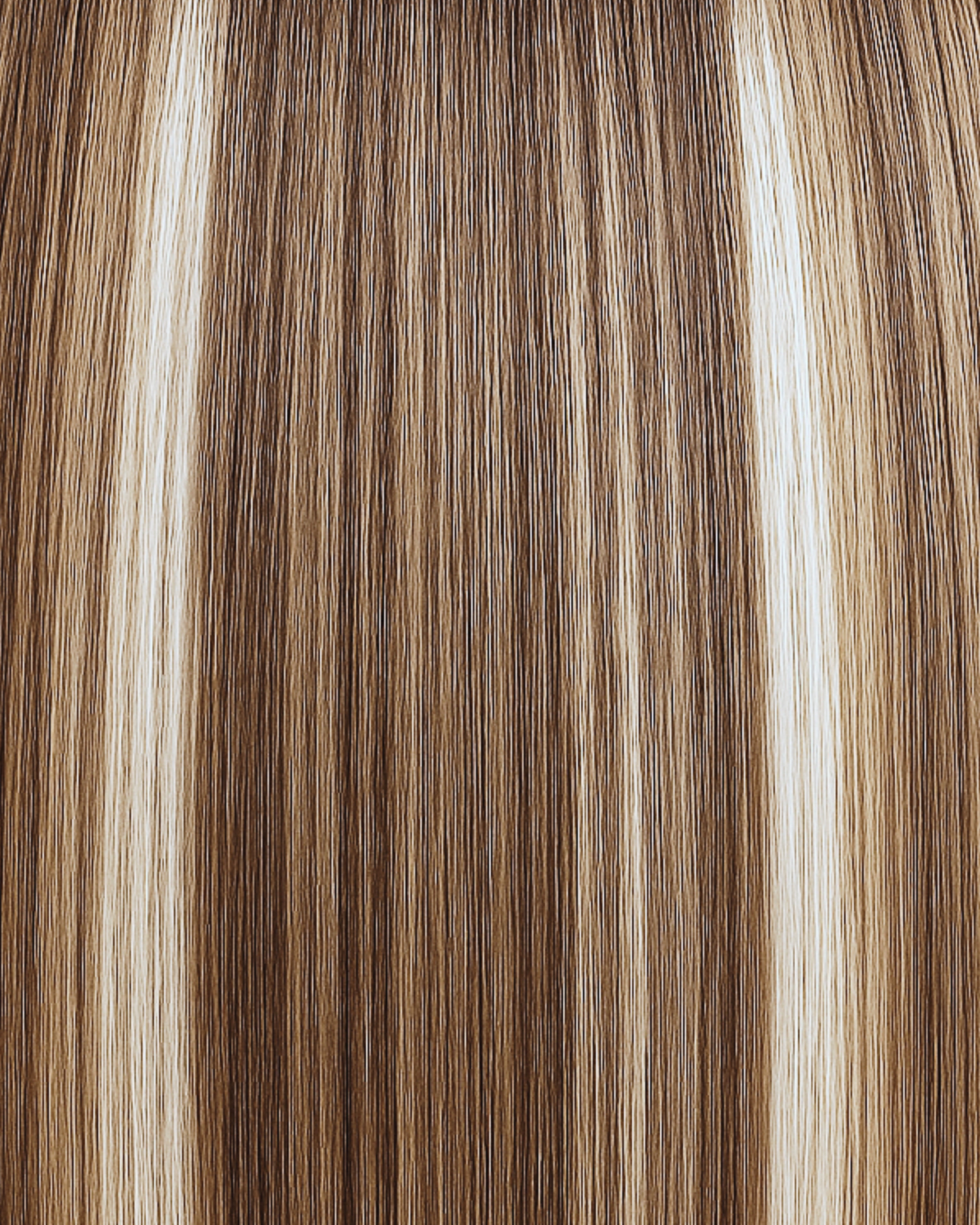 Stitched Hair Confidence Genius Weft™ extensions in rooted dimensional brunette with 9 neutral and 7 warm blend and level 7 root, shown in long sleek strands.